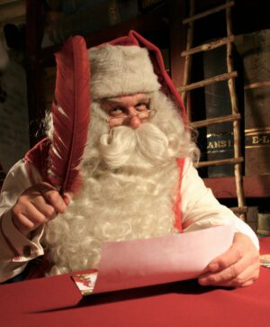 Le Père Noël écrit une carte de voeux dans son Bureau à Rovaniemi
