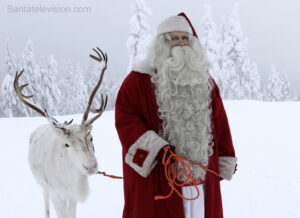 Le Père Noël marche dans la nature avec son renne en Laponie