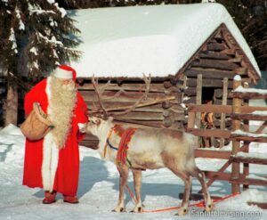 Papá Noel / Santa Claus alimentando a un reno en la Laponia finlandesa.