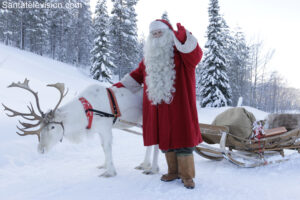 Der Weihnachtsmann und eines seiner Rentiere im Wald in Lappland, Finnland