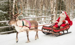 Weihnachtsmann macht Rentierschlittenfahrt im Weihnachtsmanndorf in Lappland
