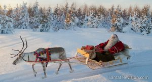 Papá Noel dando un paseo en reno en Navidad en Laponia, Finlandia